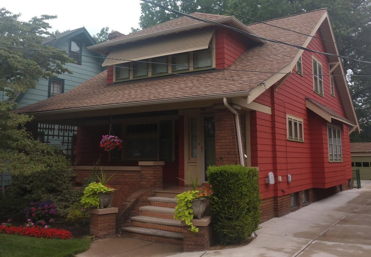 Completed deep red Craftsman-style home exterior with dark trim