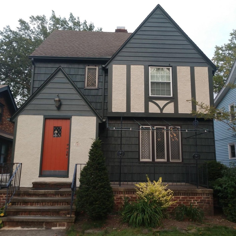 Completed dark Tudor-style exterior with contrasting light stucco panels