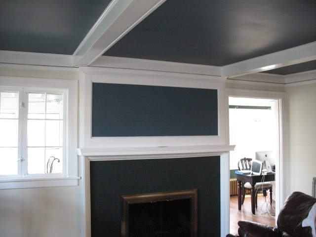 Completed interior room with a dark accent wall, white trim, and fireplace