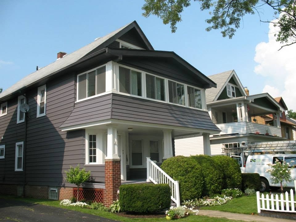 Dark refinished siding on a two-story home after refinishing